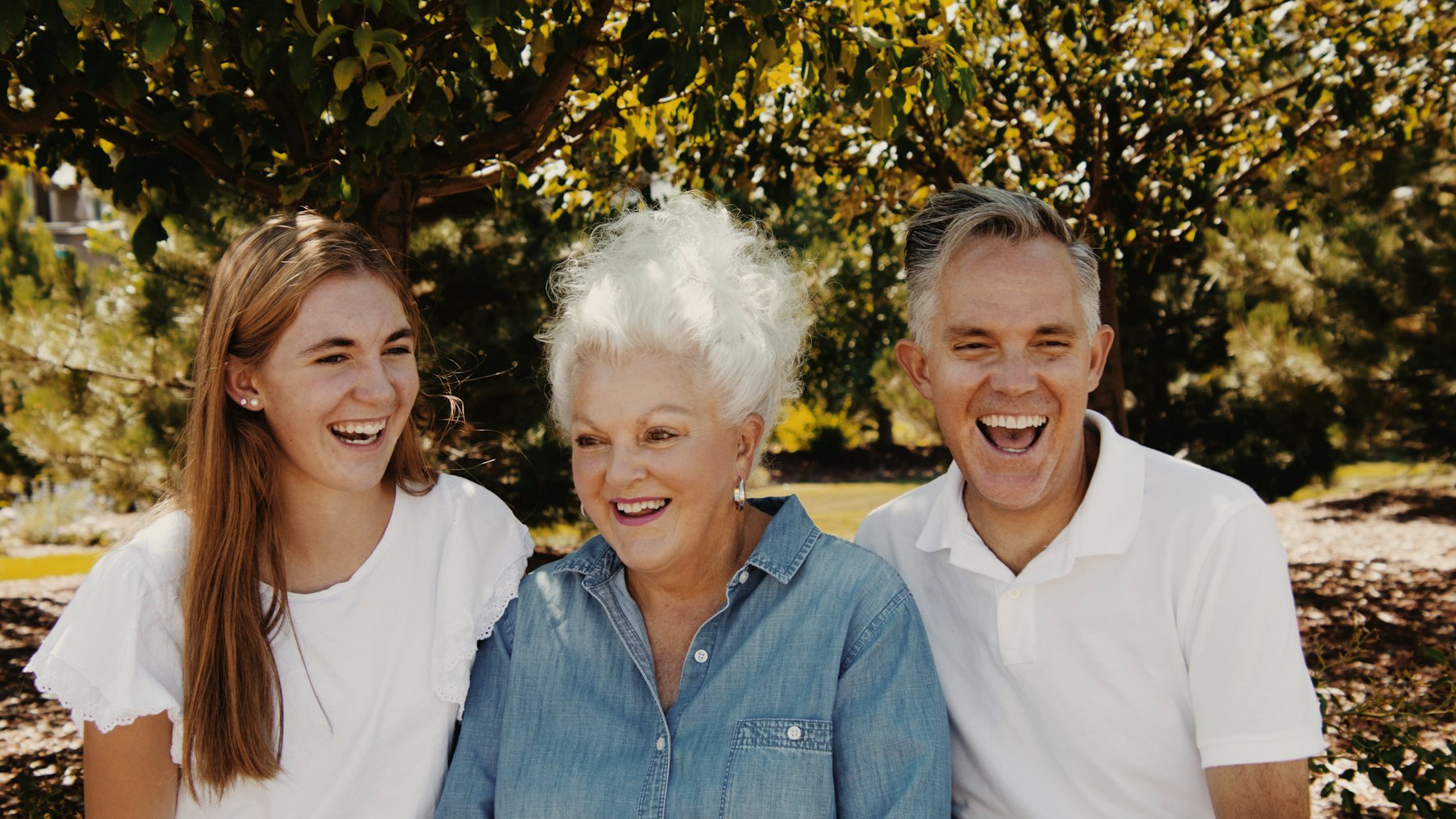 An older woman laughing with her adult children